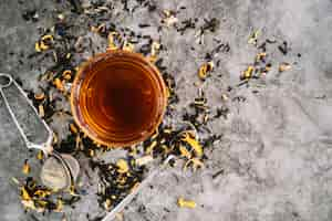 Free photo flat lay cup of tea with infuser on marble background