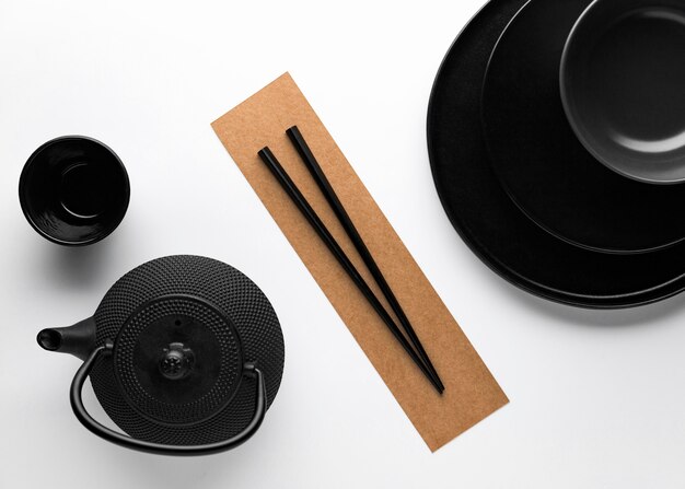 Flat lay of dark dinnerware with teapot