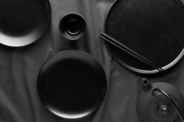 Free photo flat lay of dark plates and chopsticks