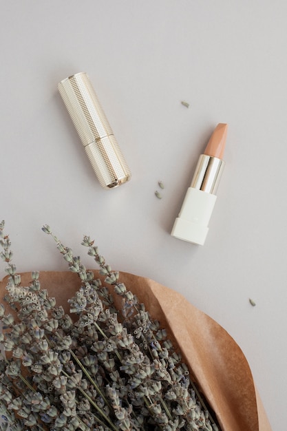 Free photo flat lay decoration with brown lipstick and plant