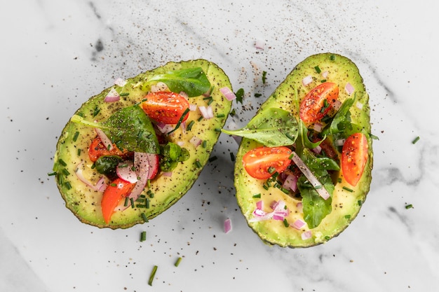 Flat lay delicious healthy salad in avocado composition