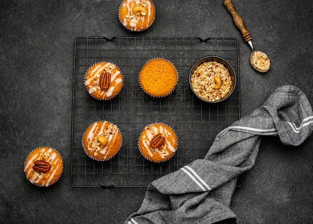 Free photo flat lay of delicious muffins with nuts on cooling rack