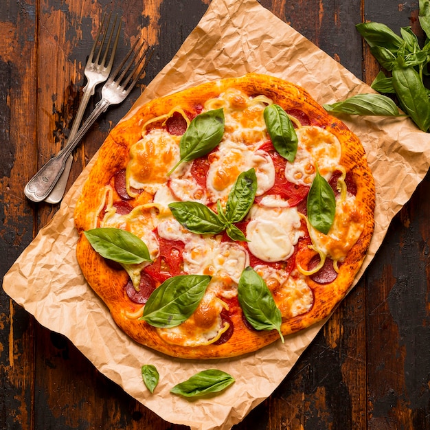 Flat lay of delicious pizza concept on wooden table