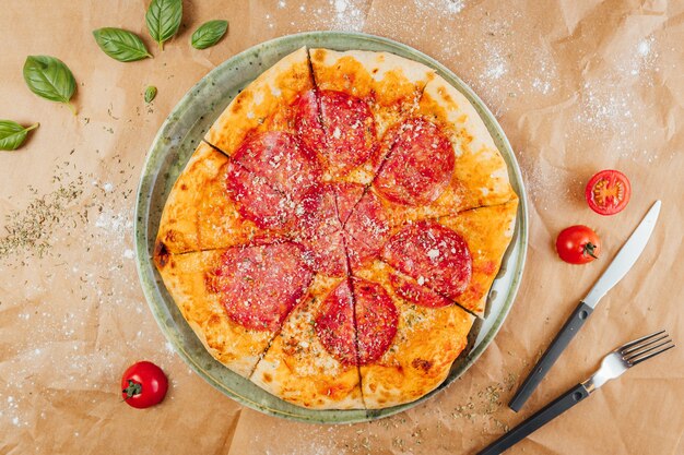 Flat lay of delicious pizza with fork and knife