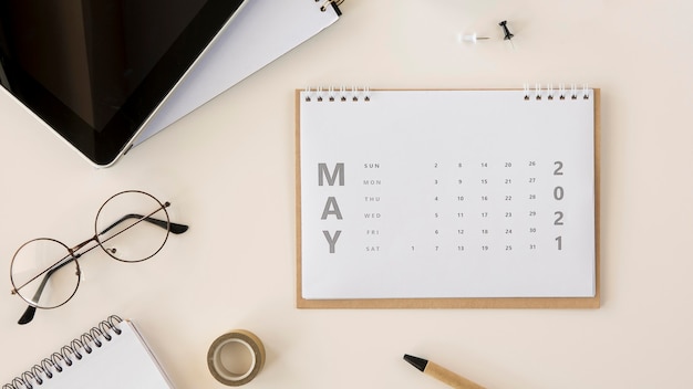 Free photo flat lay desk calendar and reading glasses