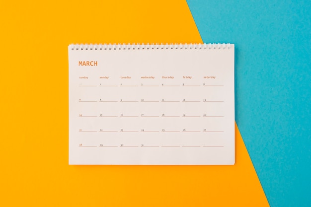 Free photo flat lay desk calendar on yellow and blue background