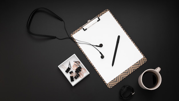 Free photo flat lay of desktop with headphones and notepad