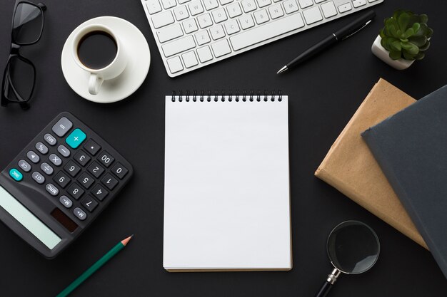 Flat lay of desktop with notebook and agendas