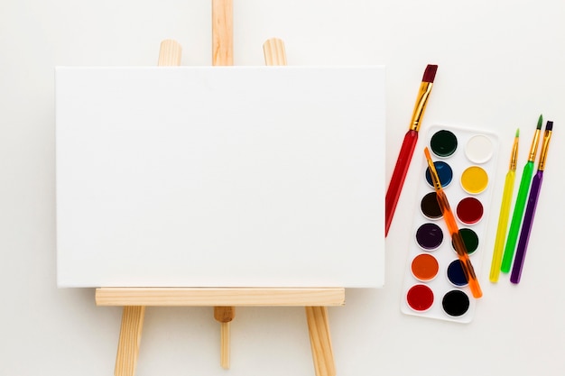 Free photo flat lay easel and watercolor paint