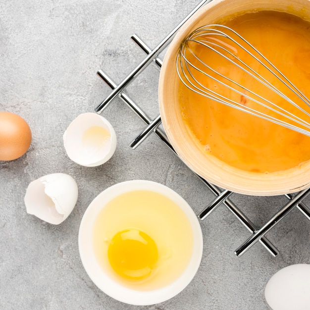 Flat lay egg shells and whisk arrangement