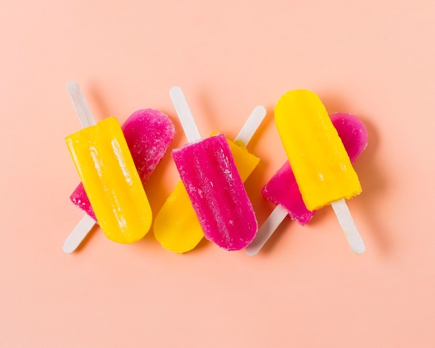 Free photo flat lay flavored ice cream on sticks