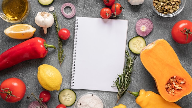 Free photo flat lay of food ingredients with notebook and vegetables