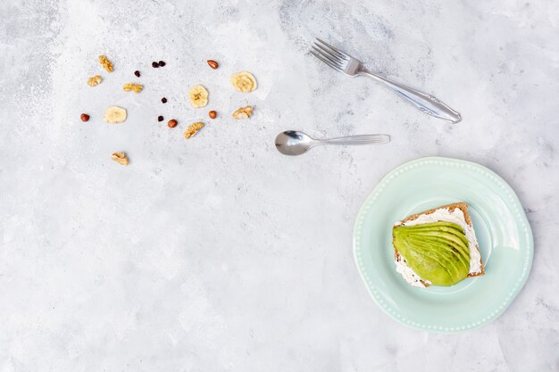 Flat lay frame with avocado and tableware