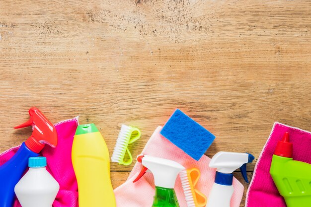 Flat lay frame with cleaning products and wooden background