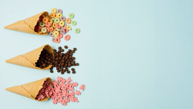 Flat lay frame with ice cream cones and cereals 