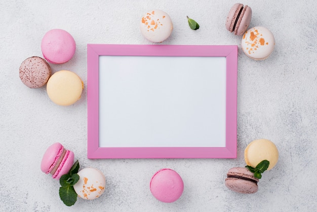 Free photo flat lay of frame with macarons and mint