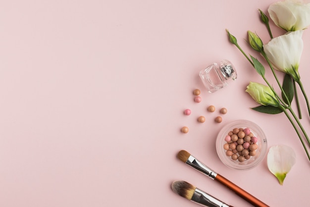 Flat lay frame with make-up products and flowers