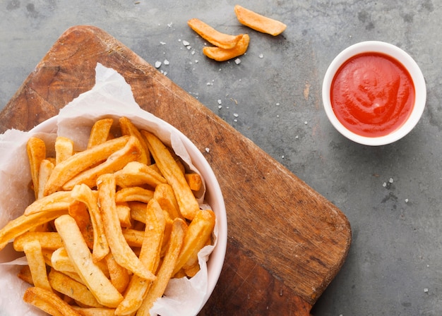 Flat lay of french fries in bowl with ketchup