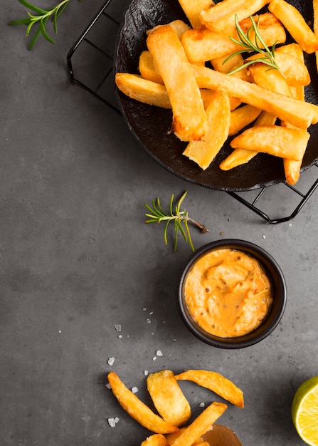 Flat lay of french fries on cooling rack with mustard