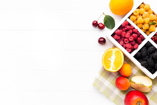 Flat-lay fresh berries and fruits with copy space