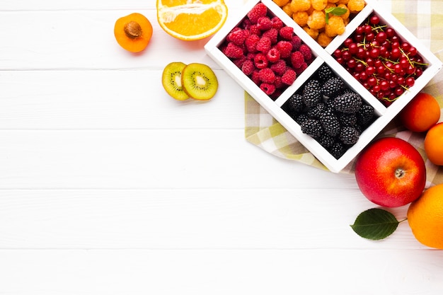 Free photo flat-lay fresh berries and fruits with copy space