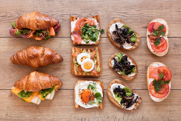 Flat lay fresh sandwiches arrangement on wooden background