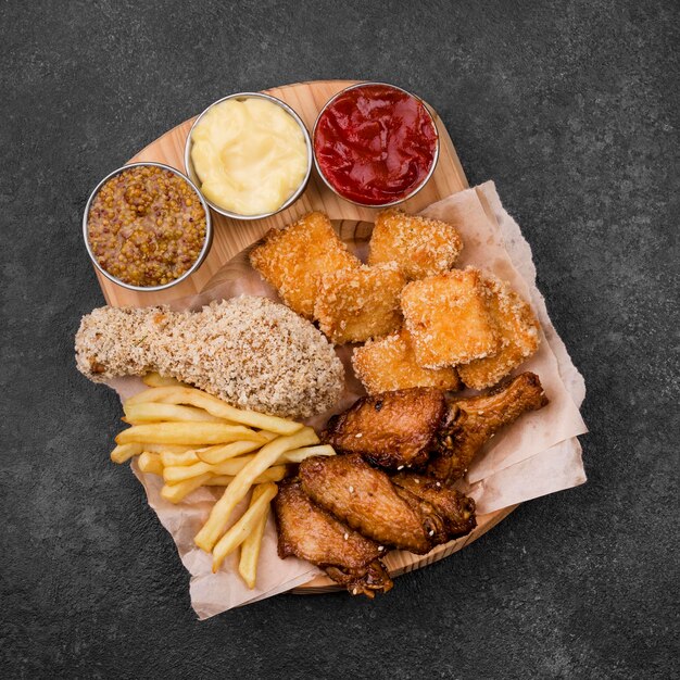 Flat lay of fried chicken with variety of sauces