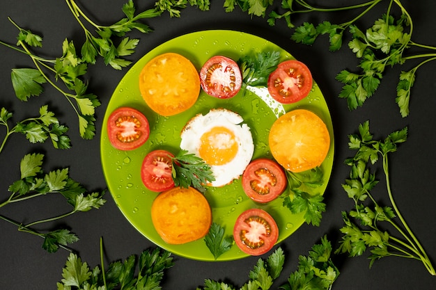 Free Photo flat lay fried egg with colorful tomatoes on plain background