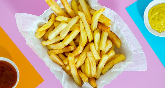 Flat lay of fries with mustard and ketchup