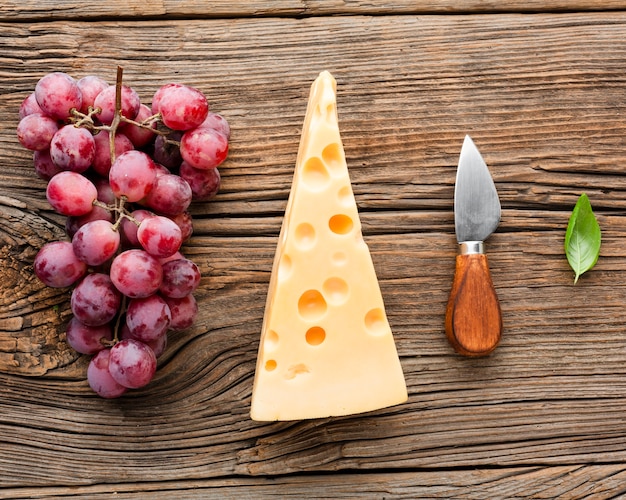 Free photo flat lay grapes emmental and cheese knife