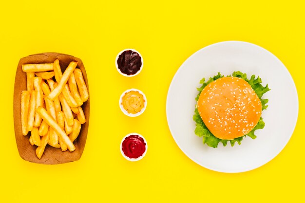 Flat lay hamburger with fries and sauces