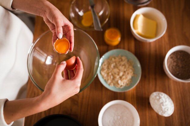 Flat lay of hands separating egg in bowl