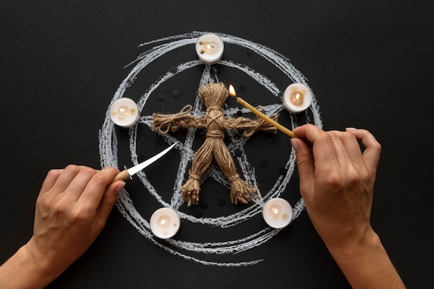 Free Photo flat lay hands stabbing voodoo doll