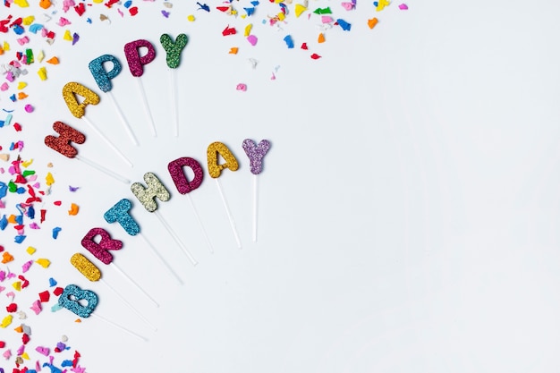 Flat lay happy birthday lettering on white background with copy space