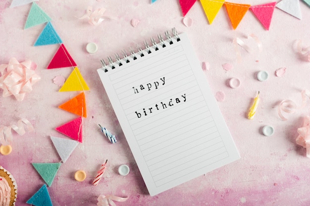 Free photo flat lay of happy birthday with on notebook with garland