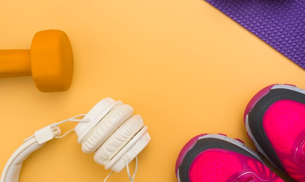 Free photo flat lay of headphones with weight and sneakers