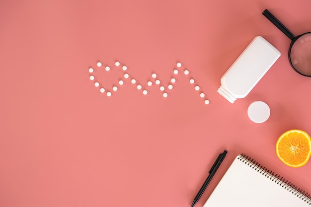 Flat lay heart cardiogram pills on pink background conceptual minimalism