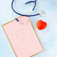 Free photo flat lay of heart shape with frame and stethoscope