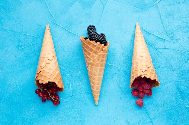 Free photo flat-lay ice cream cones with berries