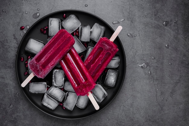 Free Photo flat lay ice cream on stick on plate with ice cubes