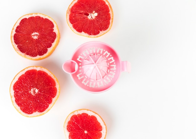 Flat lay juicer and grapefruit in halves