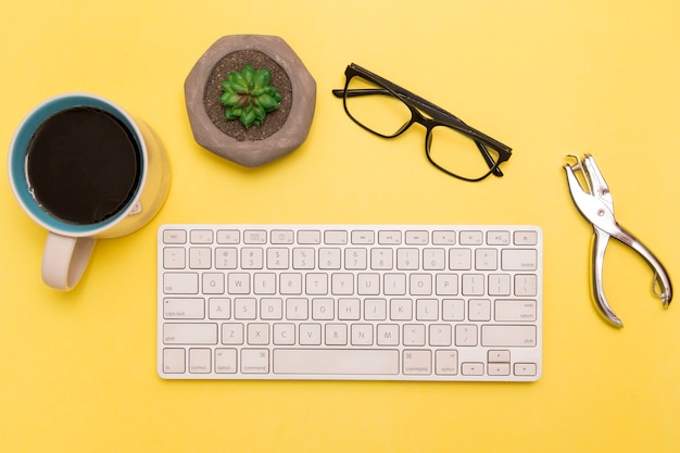 Free photo flat lay of keyboard with coffee and clippers