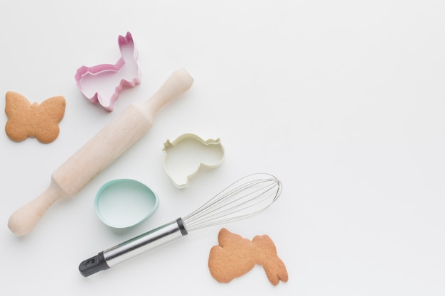 Free photo flat lay of kitchen utensils and bunny shaped forms for cookies