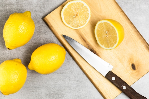 Free photo flat lay of lemons on chopper and wooden table