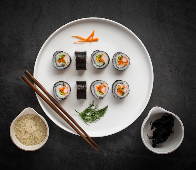 Free photo flat lay maki sushi with chopsticks