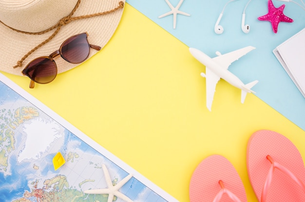 Flat lay of map, hat and sandals