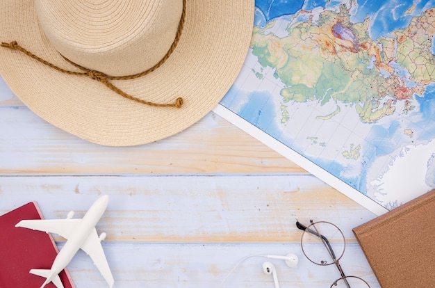 Free photo flat lay of map and hat on wooden table