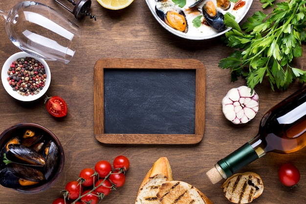 Free photo flat-lay mediterranean diet with mussels with blackboard