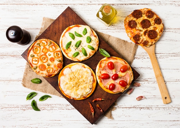 Free photo flat lay of mini pizza on wood tray