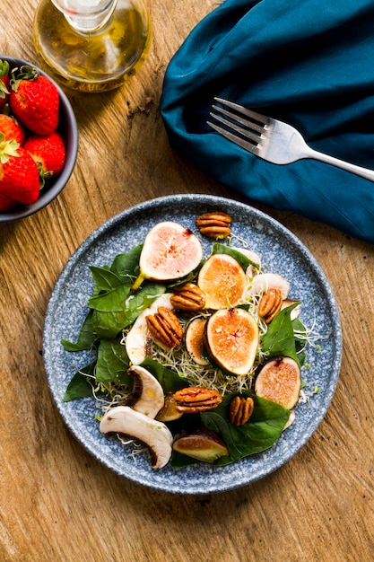 Free photo flat lay mix of nuts and figs on plate with strawberries